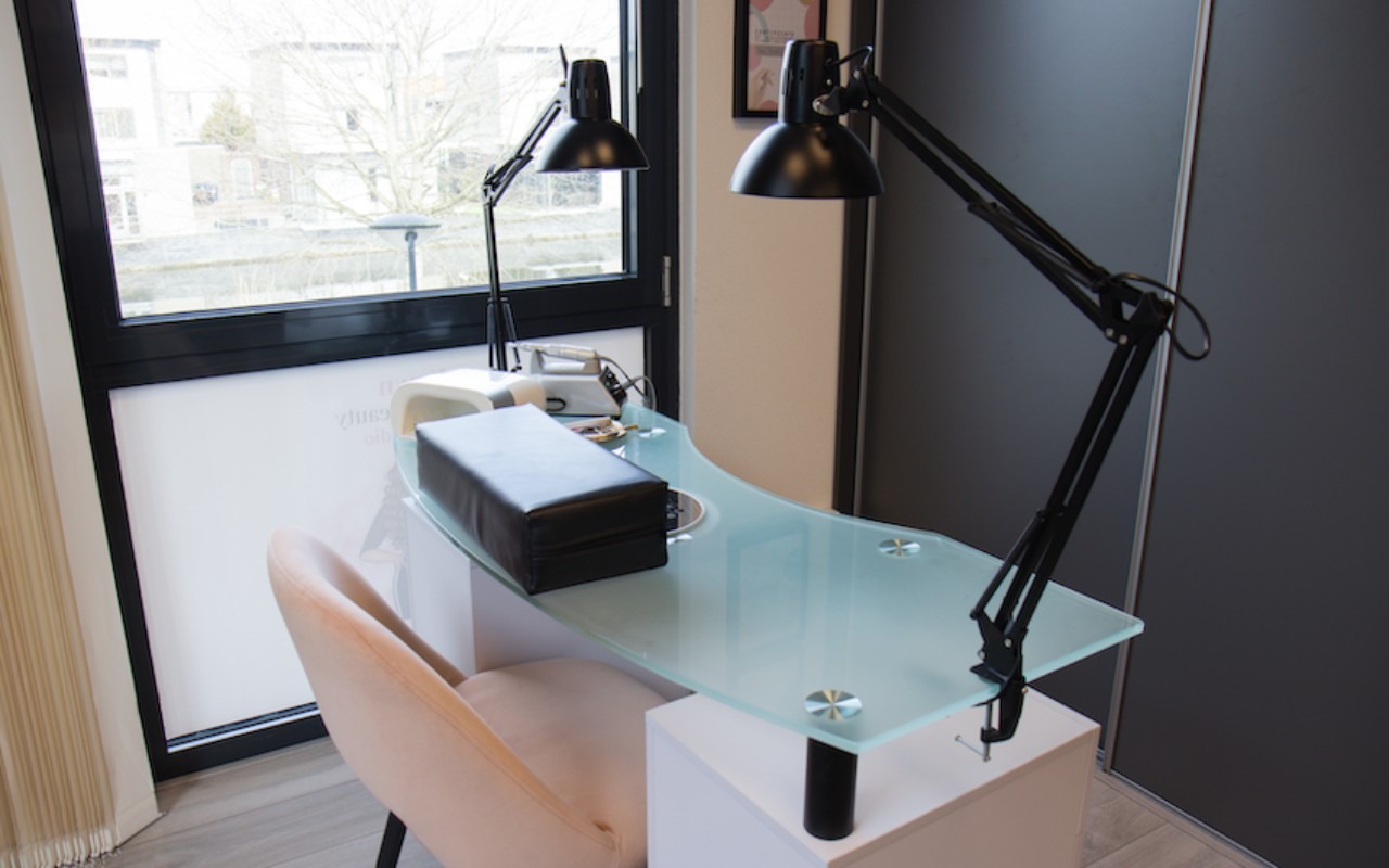 De nageltafel met matglazen blad en twee zwarte lampen